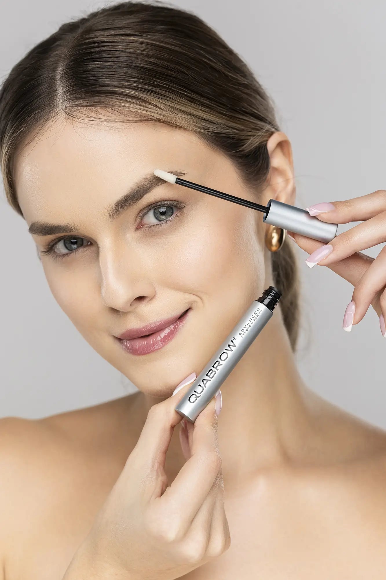 옅은 색 눈썹에 QUABROW Advanced Eyebrow Serum을 바르는 여성