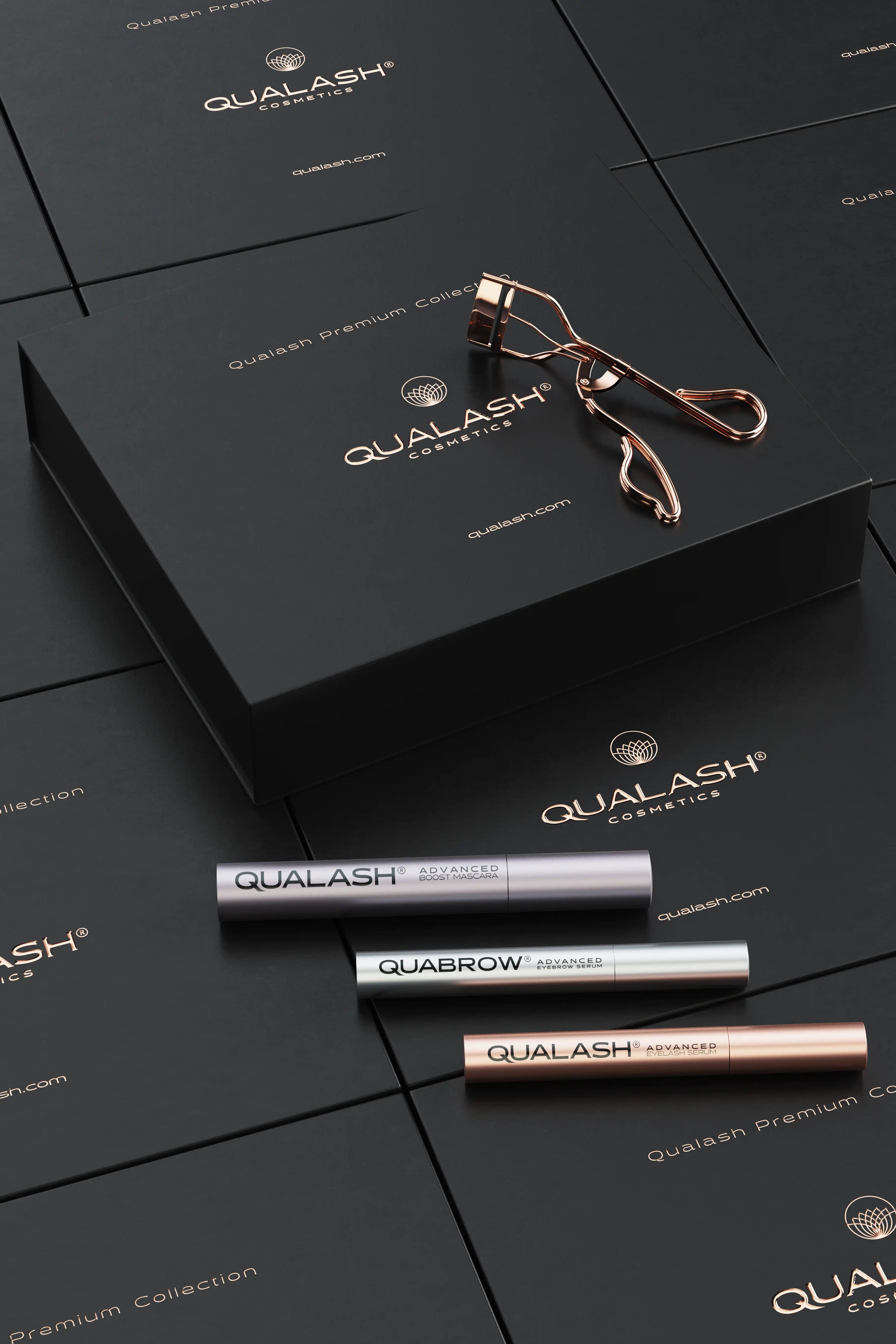 Flatlay of Qualash Premium Collection with curler and serums displayed outside the box
