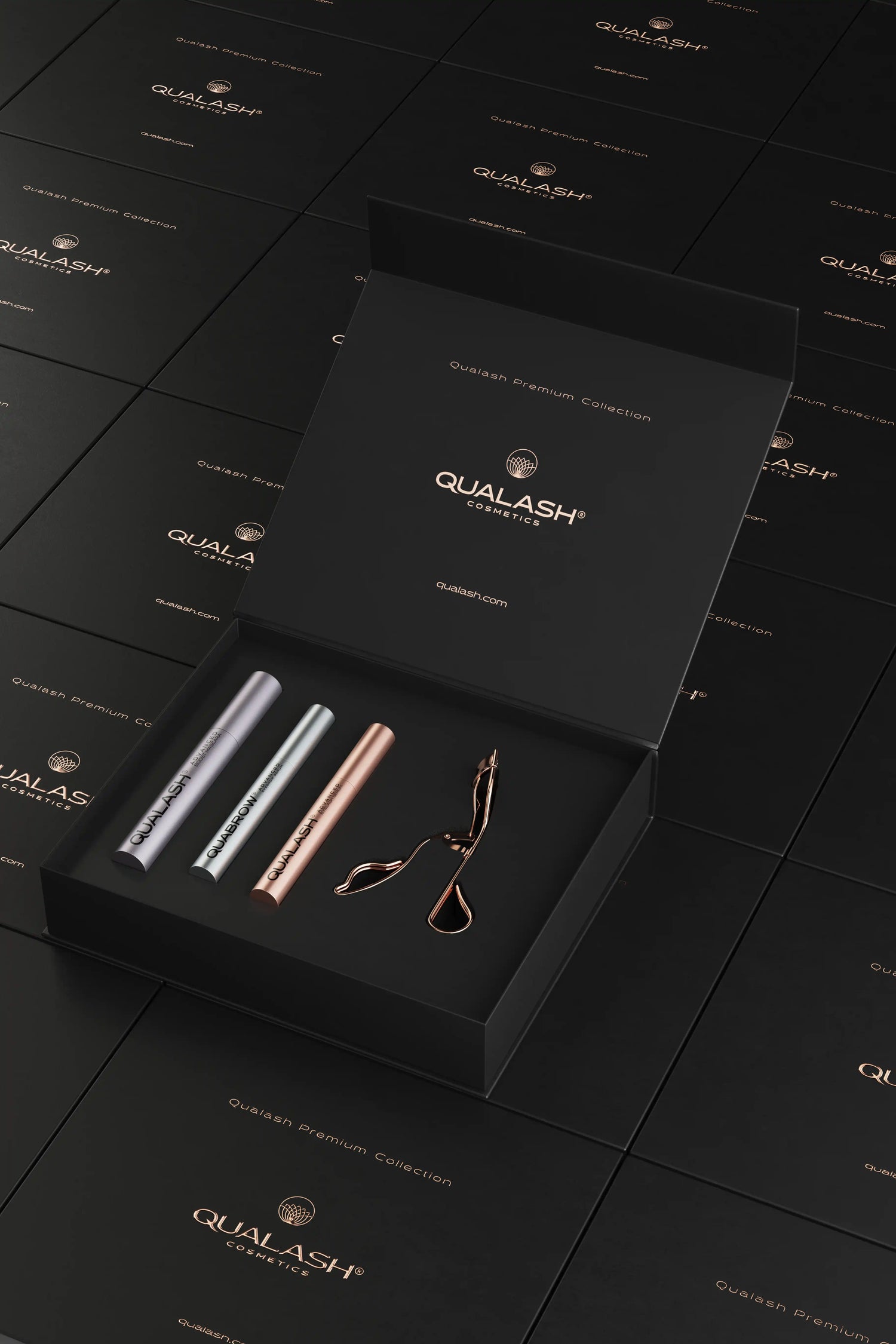 Artistic product layout of open Qualash Premium Collection set with floating boxes and curler