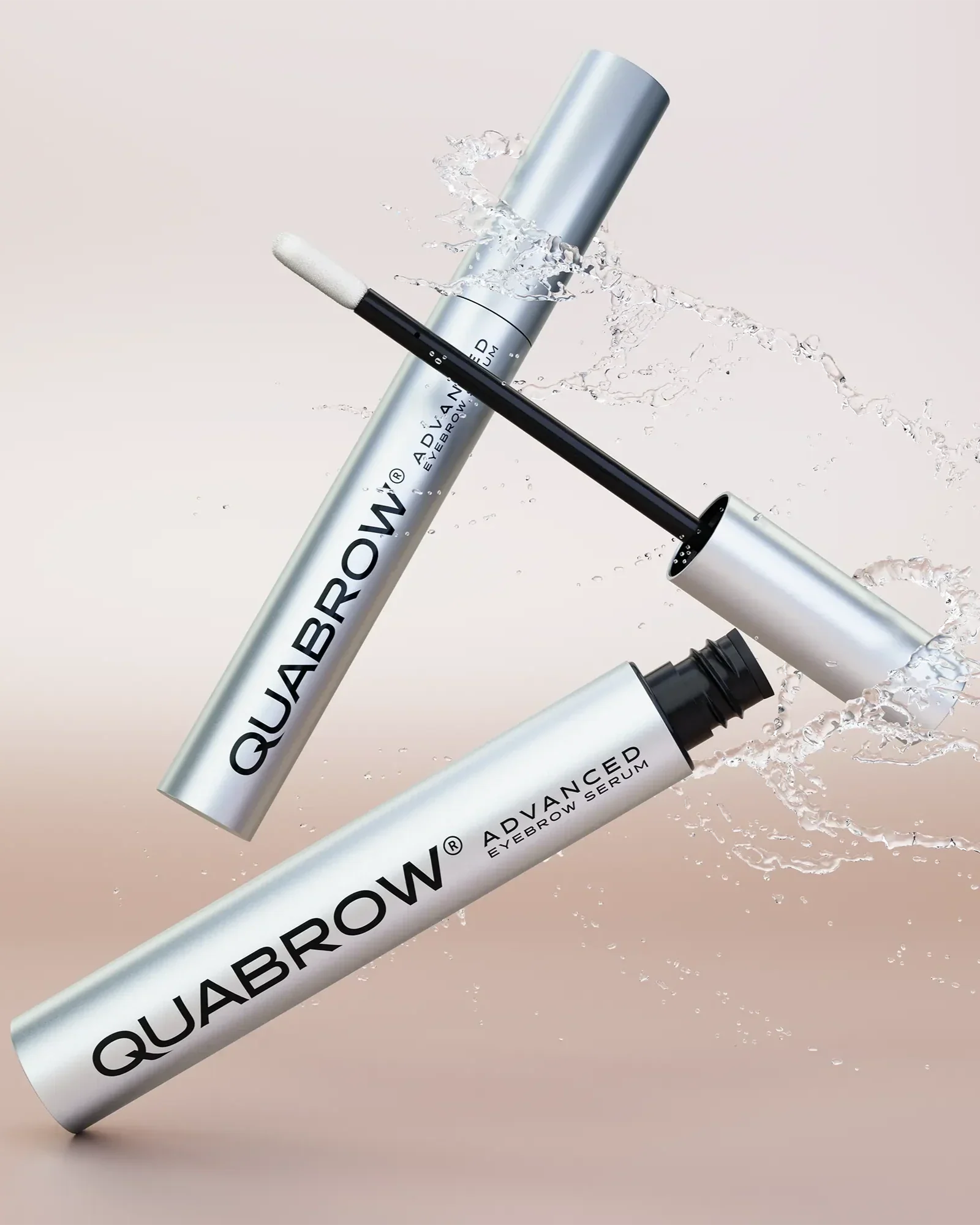 QUABROW Advanced Eyebrow Serum in dynamic splash effect on a beige background